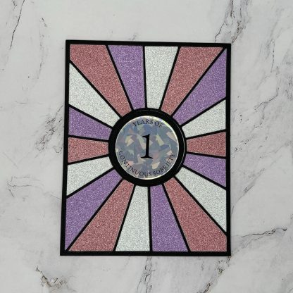Vibrant glitter sobriety anniversary card with a colorful sunburst design. Perfect for recovery milestones and supporting loved ones.