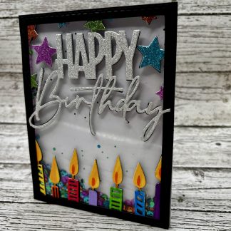 Colorful glitter birthday card with candles and celebratory message.