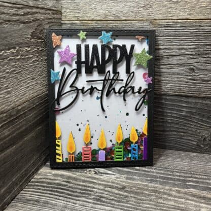 Happy birthday celebration card with colorful candles and star decorations.