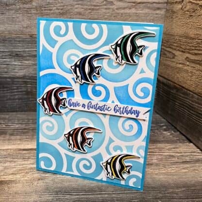 Colorful handmade birthday card with fish and swirl background.