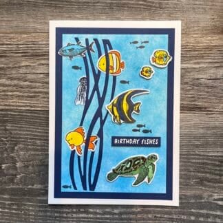 Colorful birthday fishes card with vibrant fish illustrations and seaweed design.