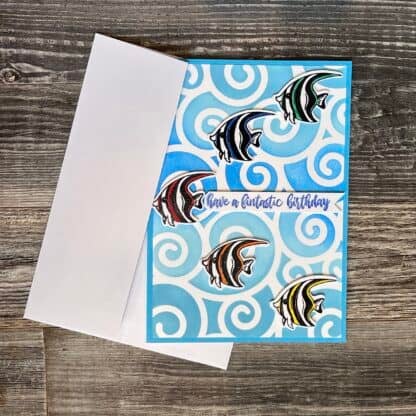Colorful fish-themed birthday card with swirl background and message.