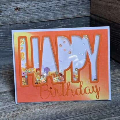 Colorful birthday card with large cut-out letters and confetti inside.